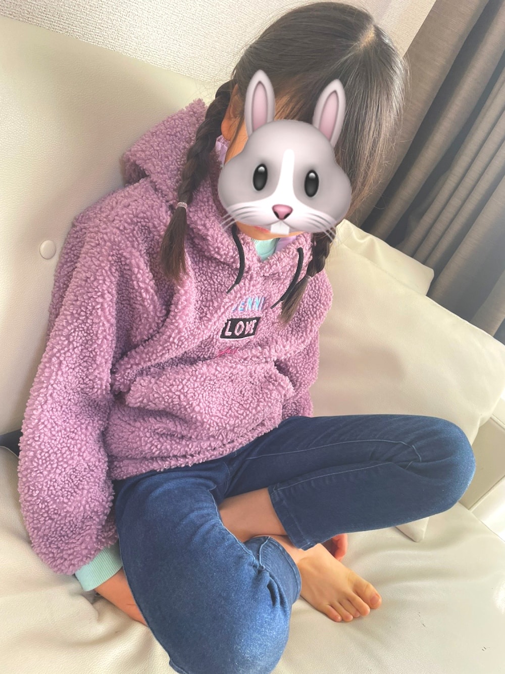 ピンク系のパーカー、ブルー系のデニムパンツ、ホワイト系のスニーカーを着用したキッズの冬コーディネートの2枚目の写真