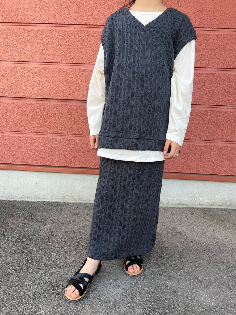 グレー系のTシャツ/カットソー、グレー系のスカート、ブラック系のサンダルを着用したキッズの夏コーディネートの2枚目の写真