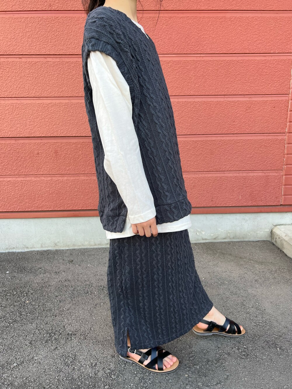 グレー系のTシャツ/カットソー、グレー系のスカート、ブラック系のサンダルを着用したキッズの夏コーディネートの3枚目の写真