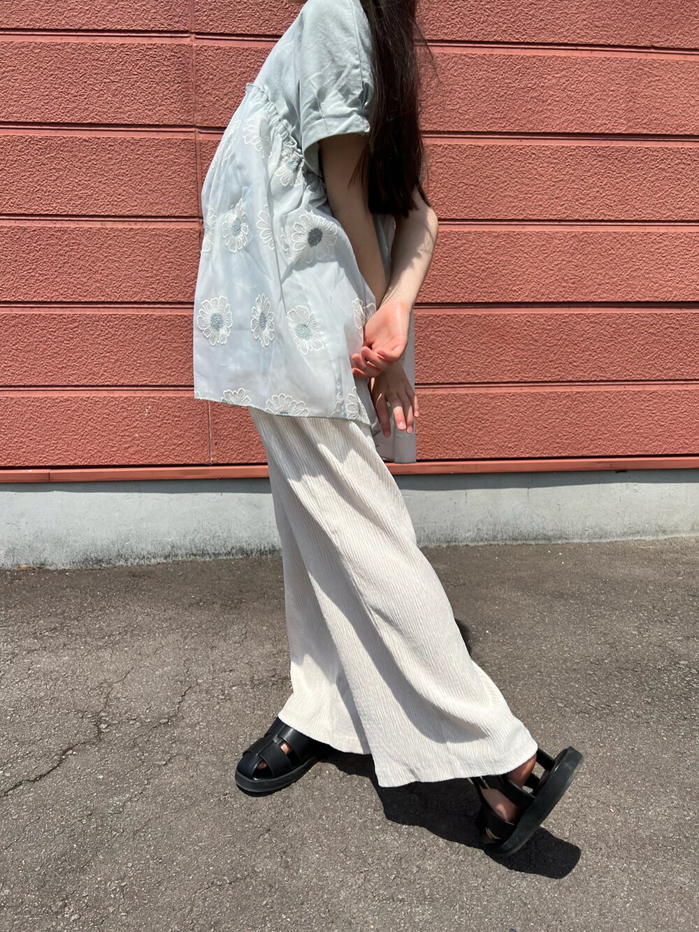 グリーン系のチュニック、ホワイト系のその他パンツ、ブラック系のサンダルを着用したキッズの春コーディネートの2枚目の写真