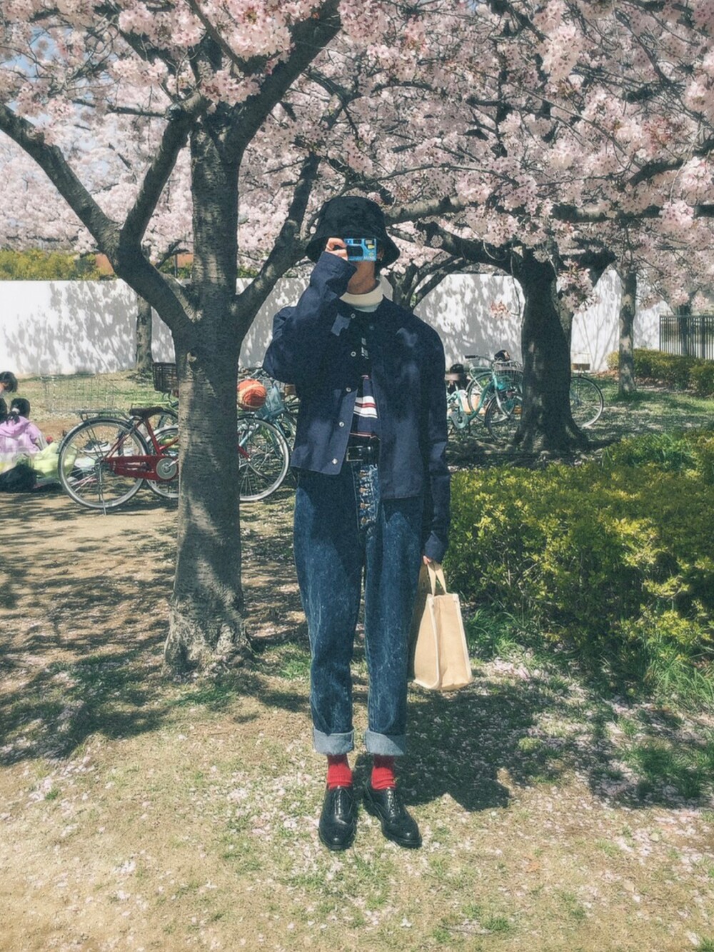 ベージュ系のバッグ、ブルー系のTシャツ/カットソー、ブラック系のシューズを着用したメンズの春コーディネートの3枚目の写真