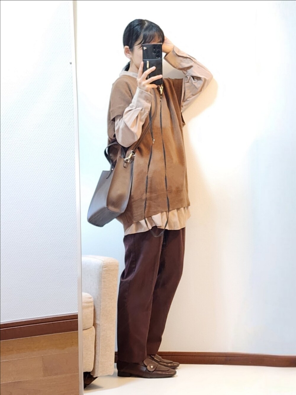 ブラウン系のベスト、ブラウン系のその他パンツ、ブラウン系のローファーを着用したレディースの秋コーディネートの2枚目の写真