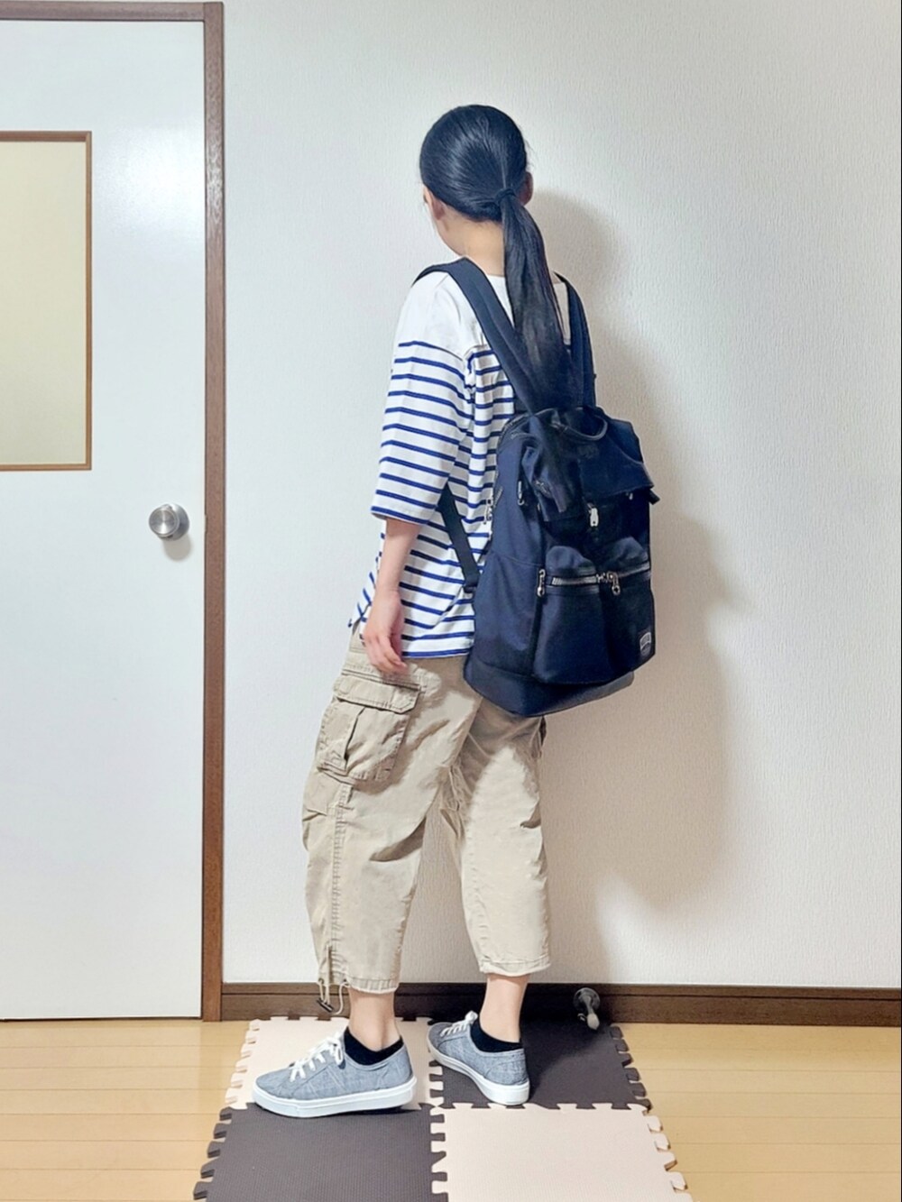 ホワイト系のTシャツ/カットソー、ベージュ系のチノパンツ、ブルー系のスニーカーを着用したレディースの夏コーディネートの2枚目の写真