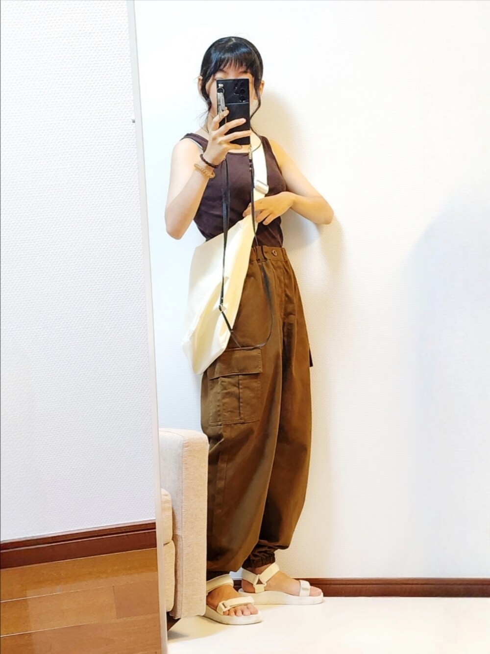 ブラウン系のカーゴパンツ、ホワイト系のサンダル、ホワイト系のシャツ/ブラウスを着用したレディースの秋コーディネートの2枚目の写真