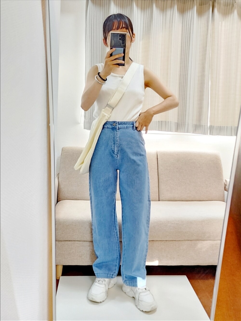 ホワイト系のシャツ/ブラウス、ブルー系のデニムパンツ、ホワイト系のスニーカーを着用したレディースの夏コーディネートの2枚目の写真