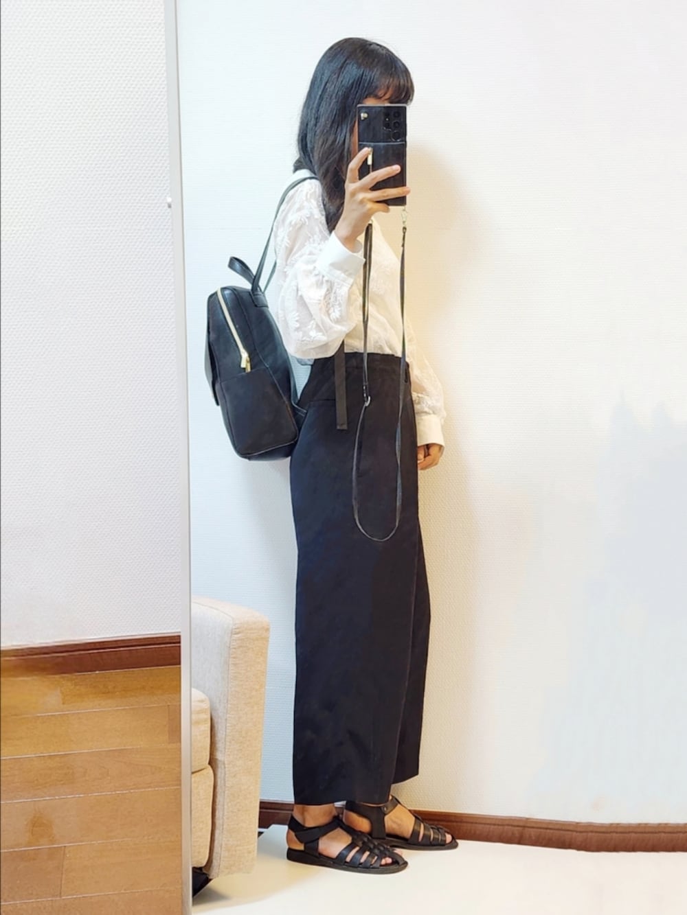 ホワイト系のシャツ/ブラウス、ブラック系のパンツ、ブラック系のサンダルを着用したレディースの秋コーディネートの2枚目の写真