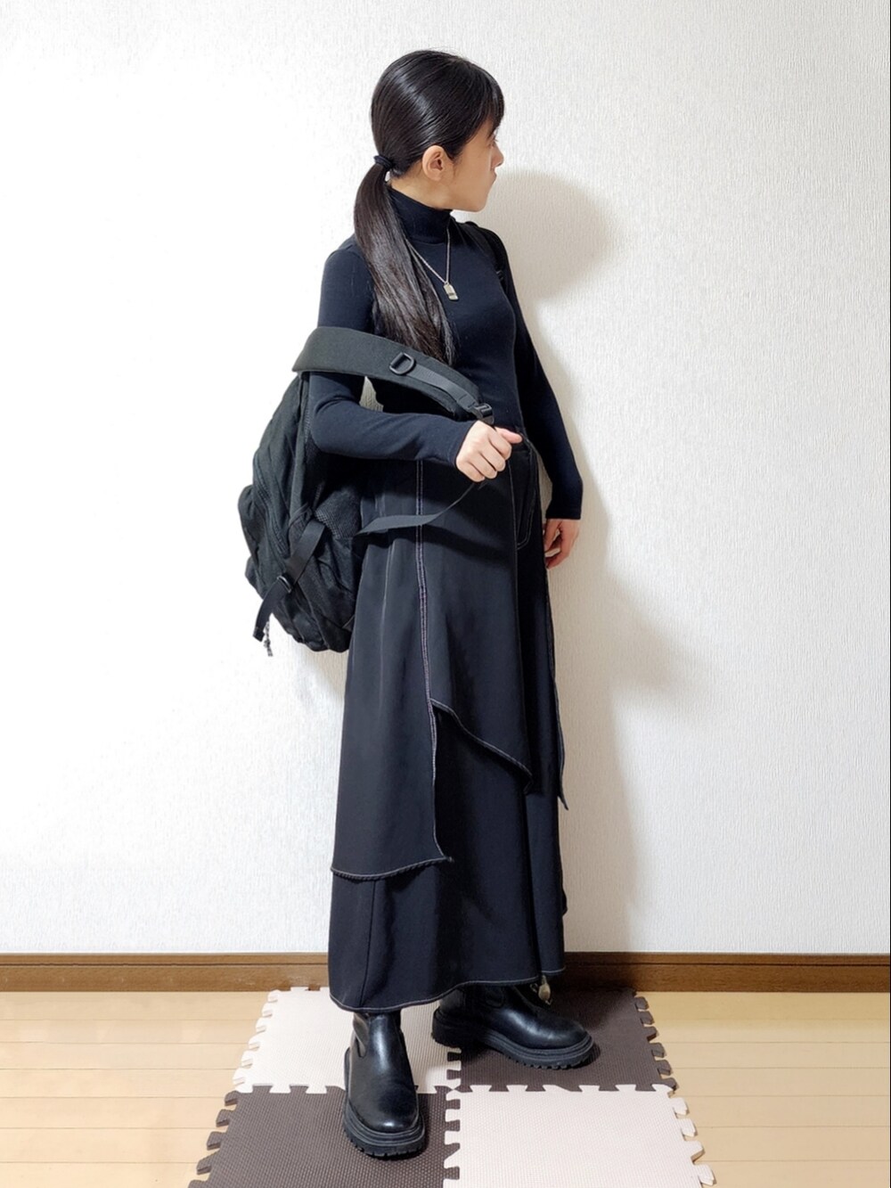 ブラック系のダウンジャケット/コート、ブラック系のバックパック/リュック、ブラック系のブーツを着用したレディースの冬コーディネートの2枚目の写真