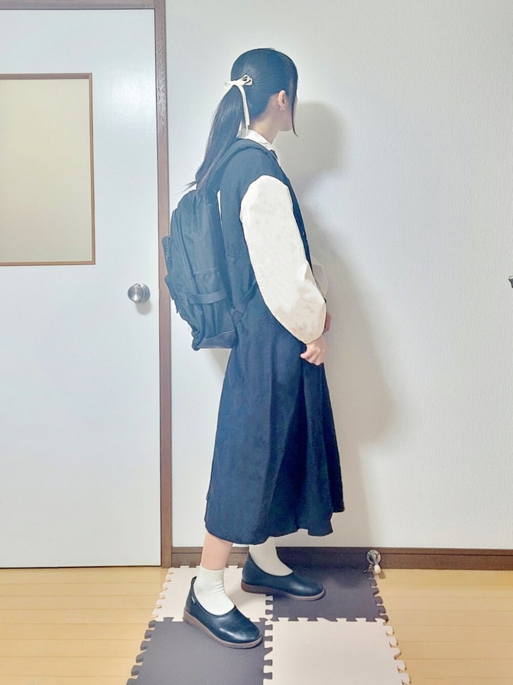 ブラック系のワンピース、ブラック系のバレエシューズ、ブラック系のバックパック/リュックを着用したレディースの夏コーディネートの2枚目の写真