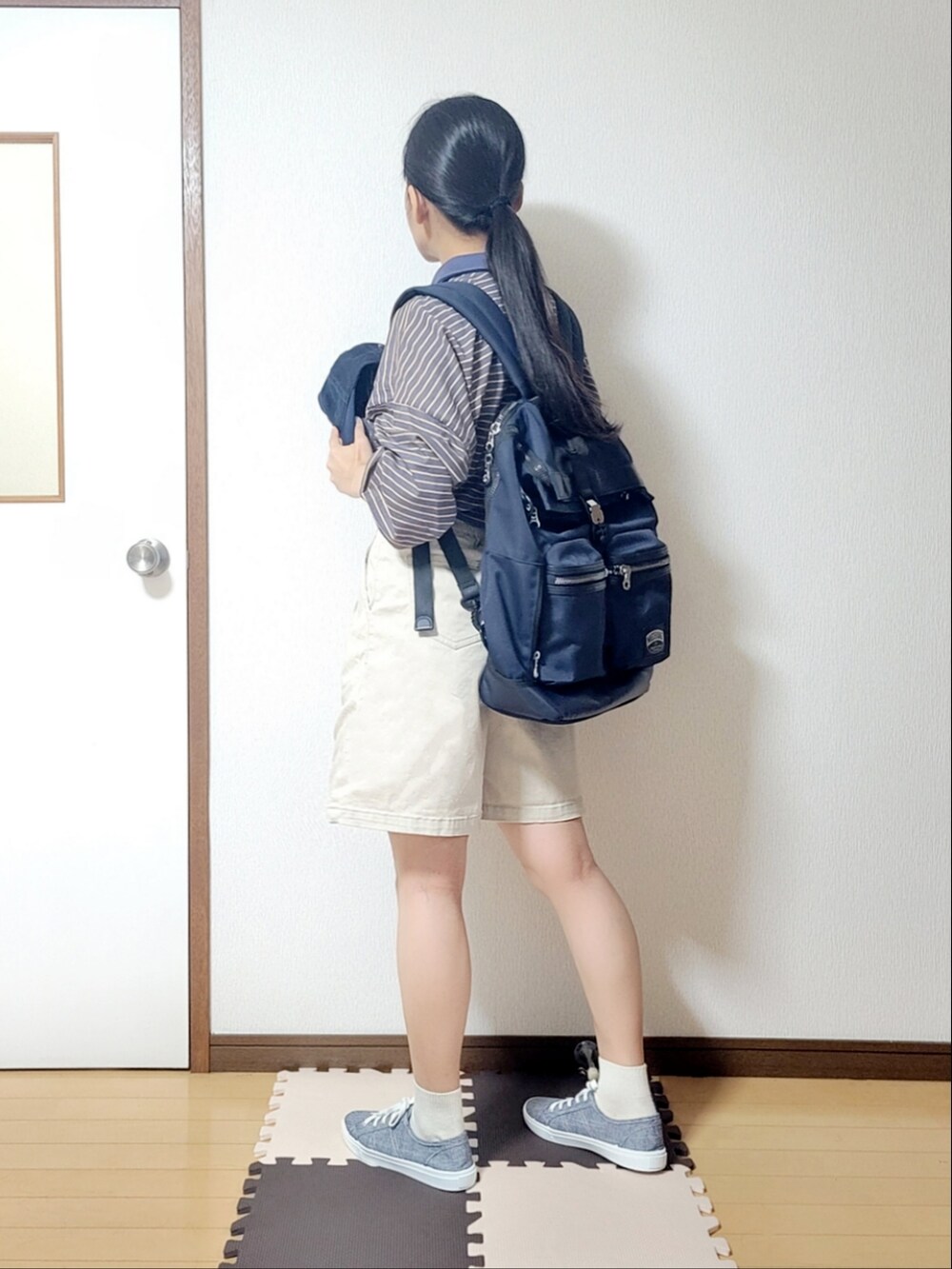 ブルー系のポロシャツ、ベージュ系のその他パンツ、ブルー系のスニーカーを着用したレディースの夏コーディネートの2枚目の写真