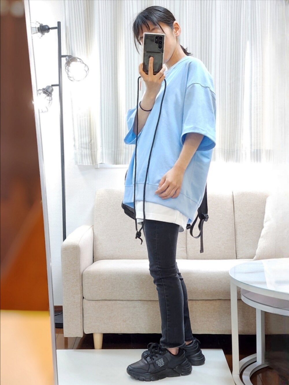 ブルー系のスウェット、ホワイト系のタンクトップ、ブラック系のバックパック/リュックを着用したレディースの春コーディネートの2枚目の写真