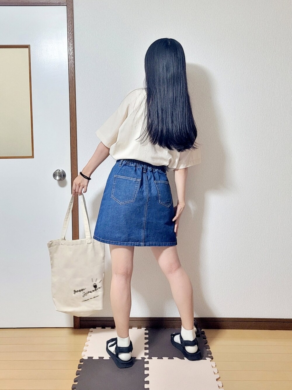 ホワイト系のシャツ/ブラウス、ブルー系のデニムスカート、ブラック系のサンダルを着用したレディースの夏コーディネートの2枚目の写真