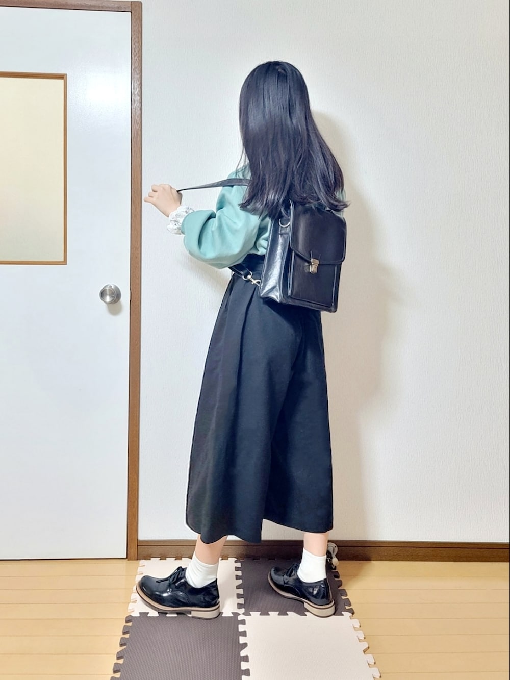 グリーン系のスウェット、ブラック系のその他パンツ、ブラック系のドレスシューズを着用したレディースの春コーディネートの2枚目の写真