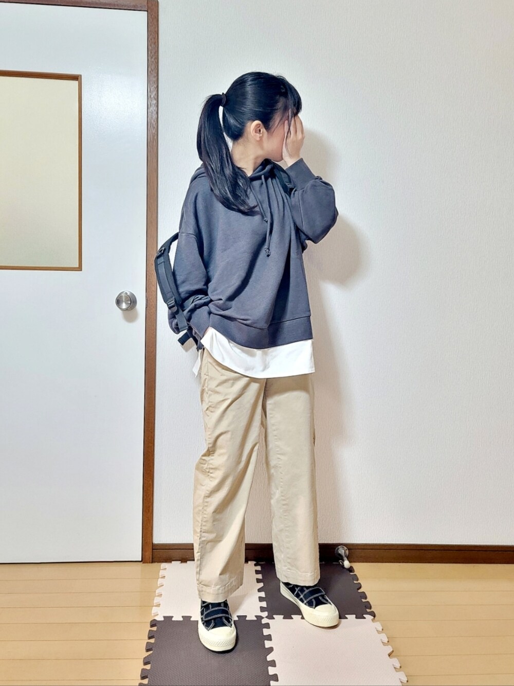 ブラック系のTシャツ/カットソー、ベージュ系のその他パンツ、ブラック系のスニーカーを着用したレディースの春コーディネートの2枚目の写真