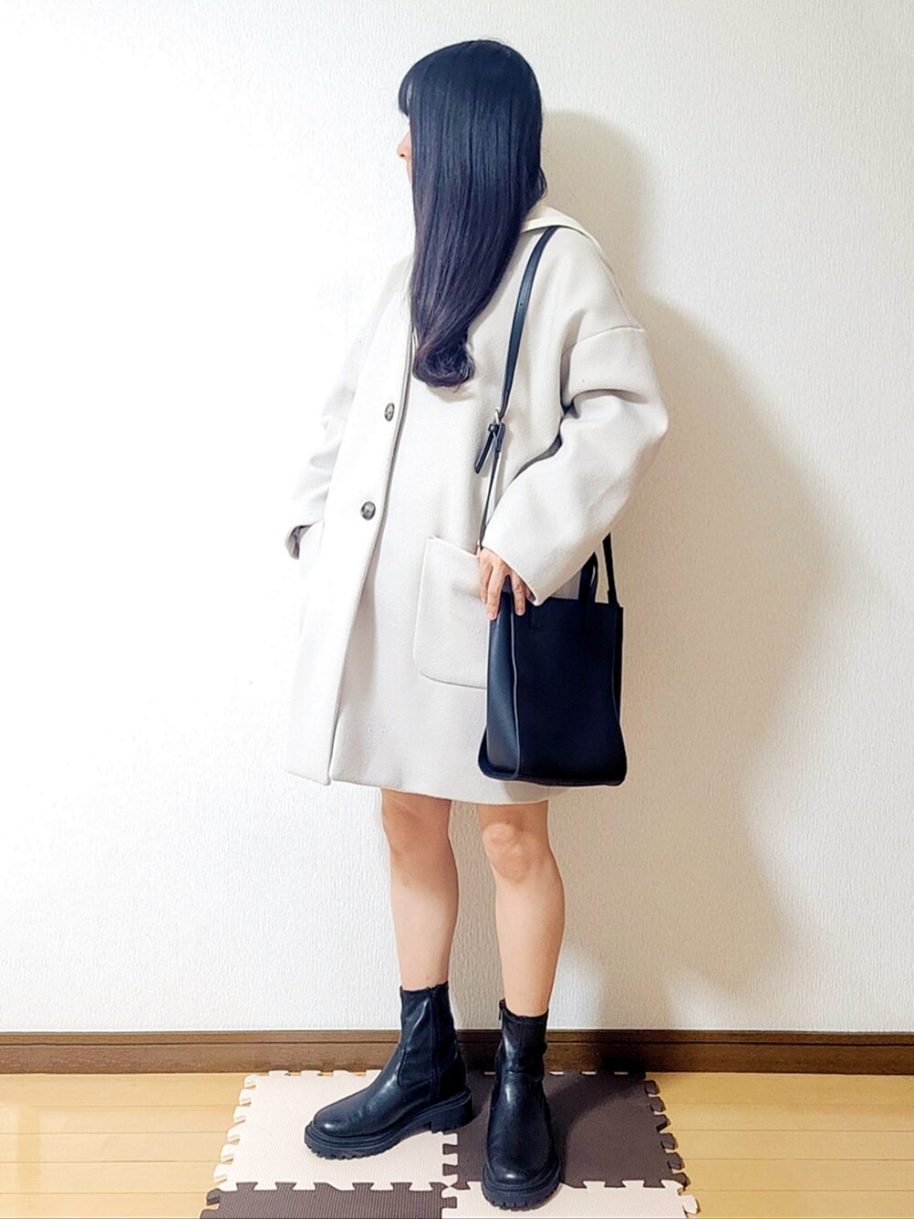 ホワイト系のニット/セーター、ブラック系のトートバッグ、ブラック系のその他パンツを着用したレディースの冬コーディネートの2枚目の写真