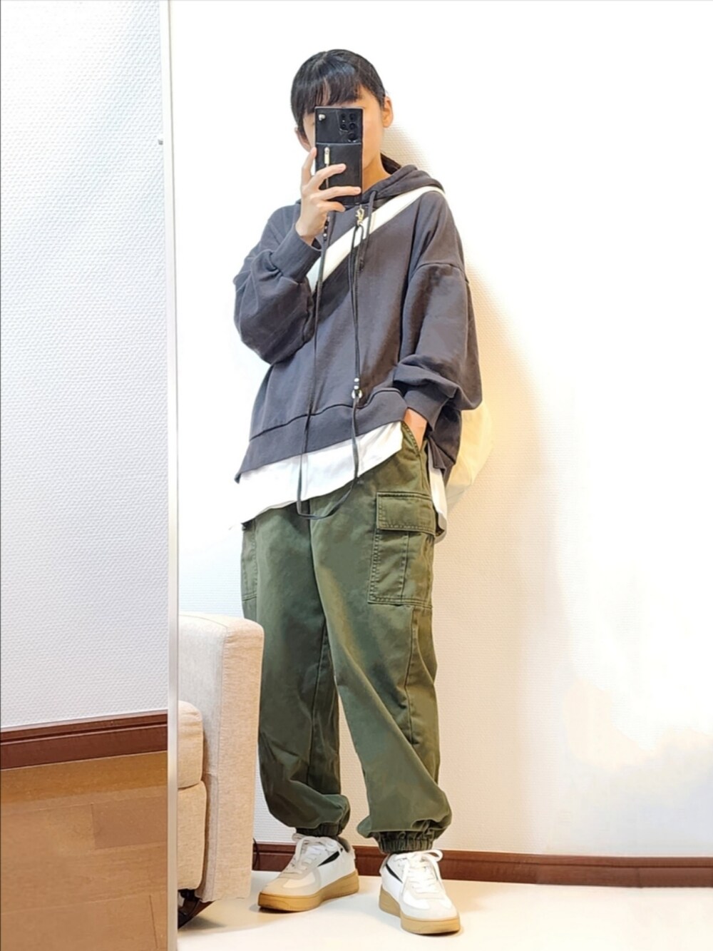 ブラック系のTシャツ/カットソー、ブラック系のカーゴパンツ、ホワイト系のスニーカーを着用したレディースの秋コーディネートの2枚目の写真