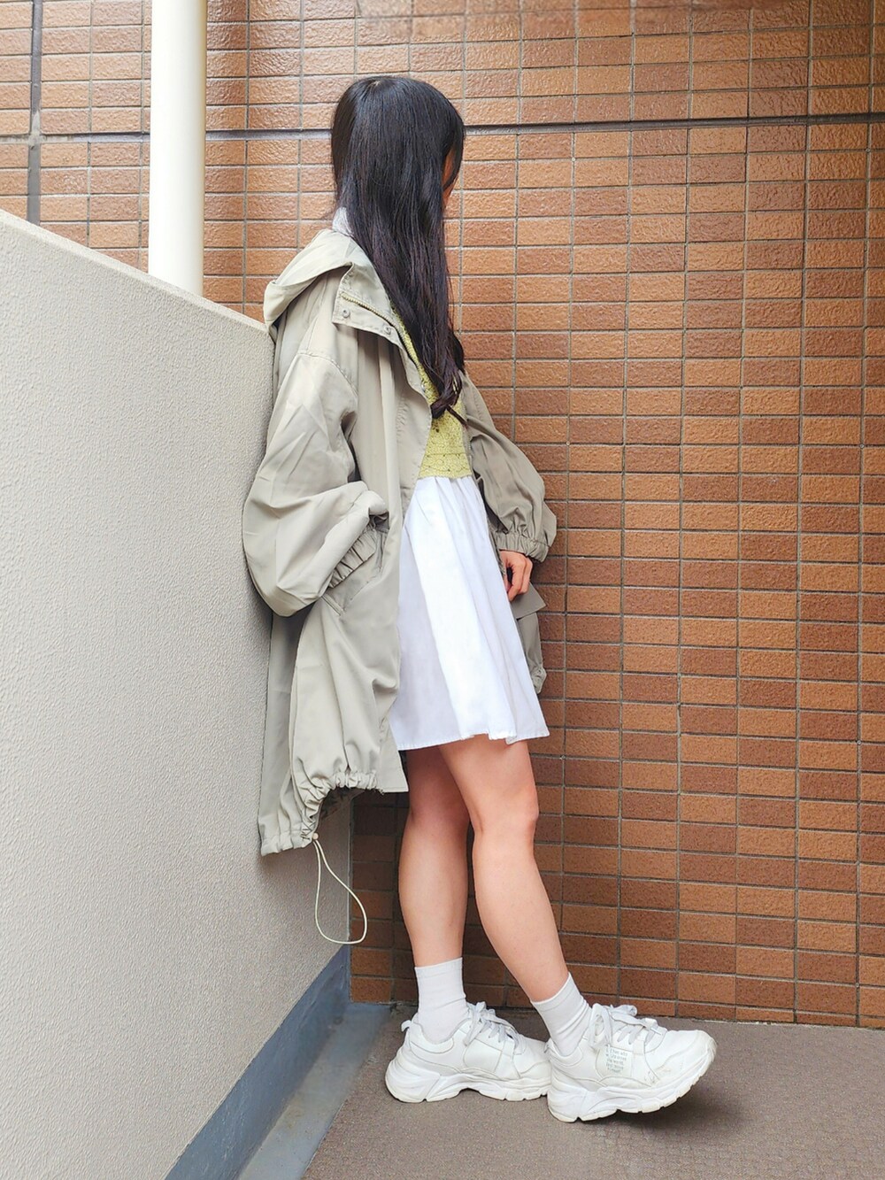 グリーン系のその他アウター、ホワイト系のショルダーバッグ、グリーン系のニット/セーターを着用したレディースの春コーディネートの2枚目の写真