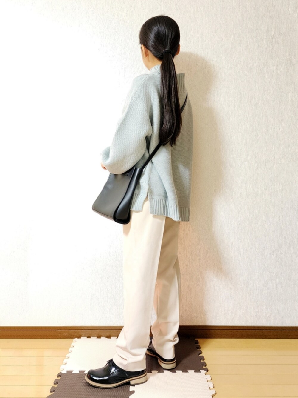 グリーン系のニット/セーター、ホワイト系のその他パンツ、ブラック系のドレスシューズを着用したレディースの冬コーディネートの2枚目の写真