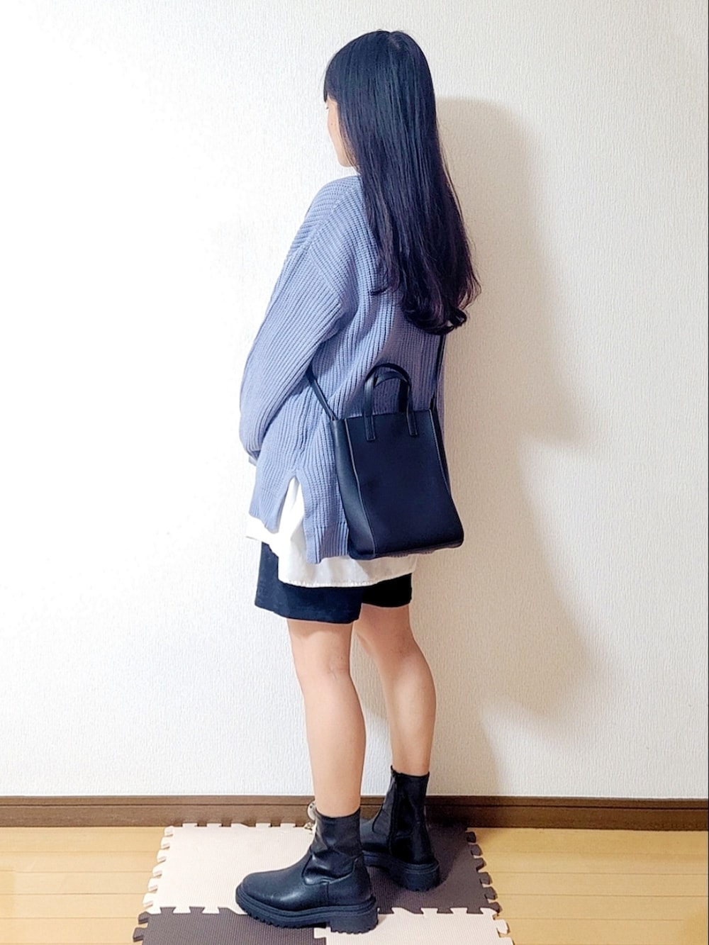 ブラック系のトートバッグ、ブラック系のブーツ、ブルー系のニット/セーターを着用したレディースの秋コーディネートの2枚目の写真