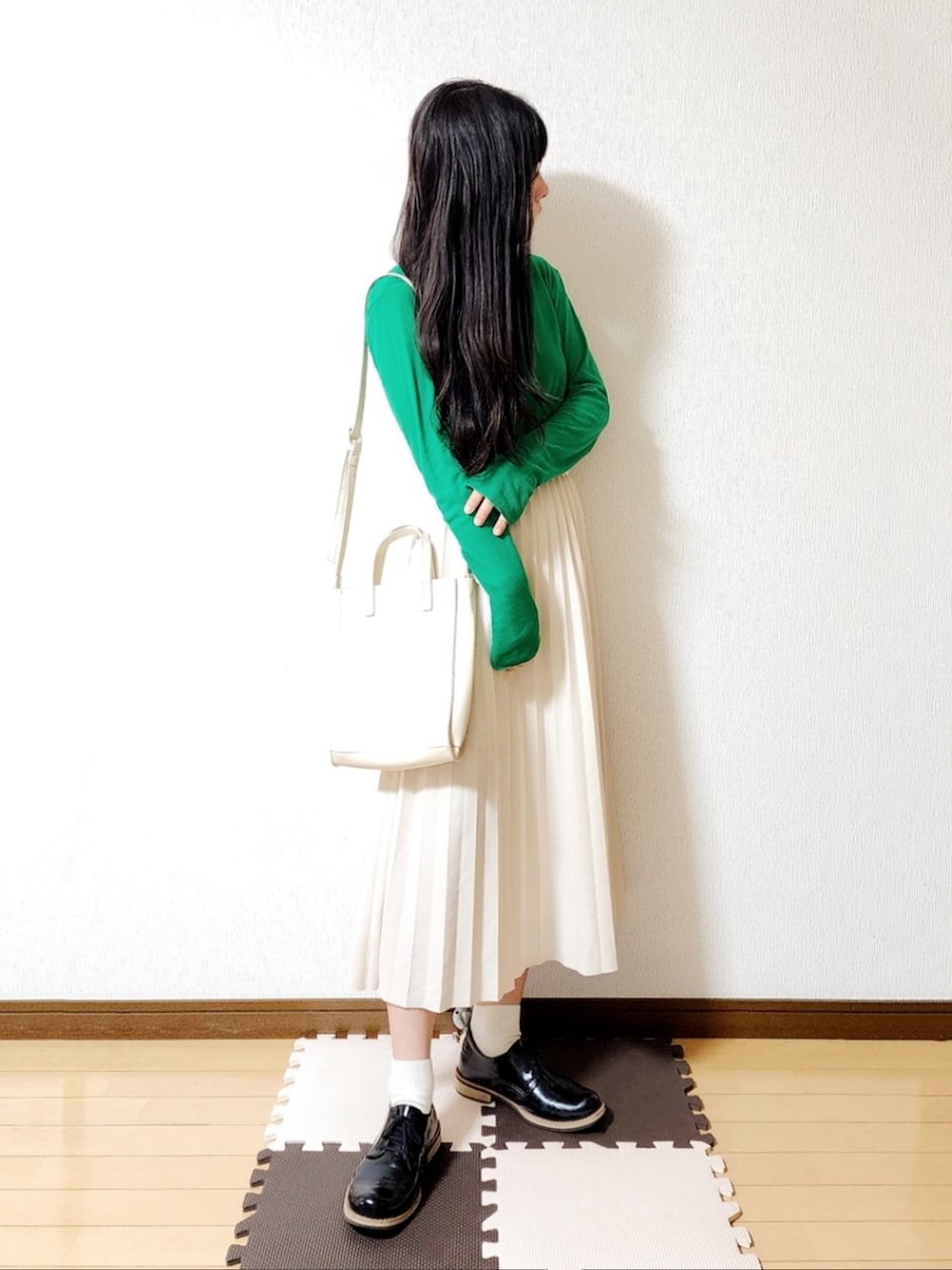 ベージュ系のスカート、ブラック系のドレスシューズ、グリーン系のTシャツ/カットソーを着用したレディースの春コーディネートの2枚目の写真