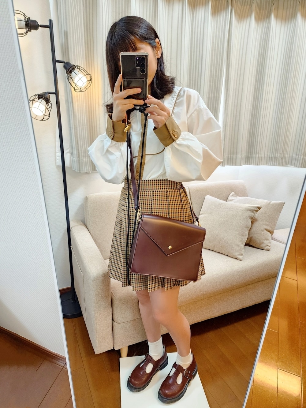 ブラウン系のブルゾン、ブラウン系のスカート、ブラウン系のショルダーバッグを着用したレディースの春コーディネートの2枚目の写真
