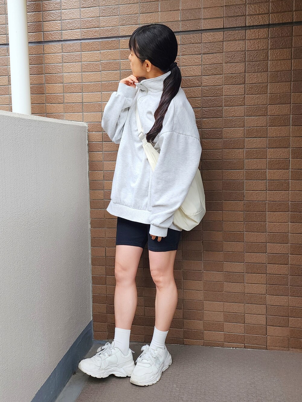 ホワイト系のスウェット、ホワイト系のショルダーバッグ、ブラック系のその他パンツを着用したレディースの春コーディネートの2枚目の写真