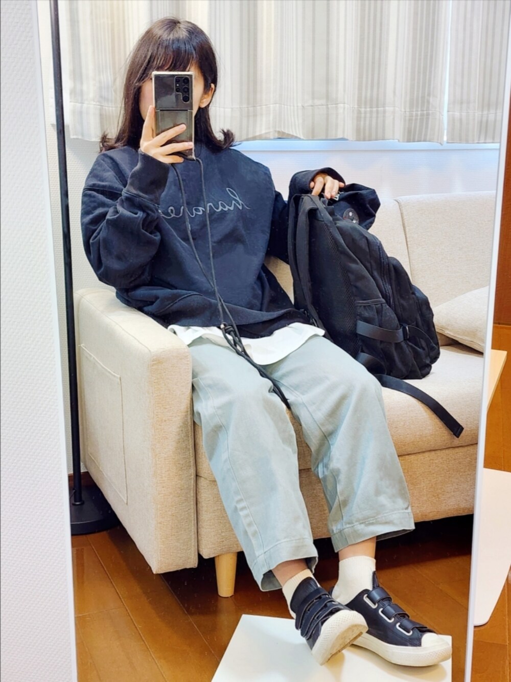 ブラック系のスウェット、ホワイト系のTシャツ/カットソー、グリーン系のデニムパンツを着用したレディースの春コーディネートの2枚目の写真