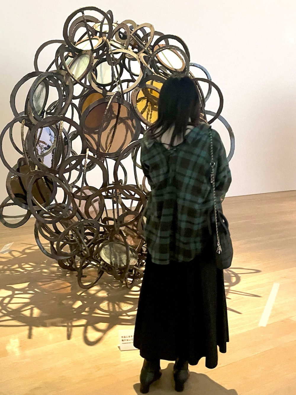 グリーン系のシャツ/ブラウス、ブラック系のショルダーバッグ、ホワイト系のニット/セーターを着用したレディースの冬コーディネートの2枚目の写真