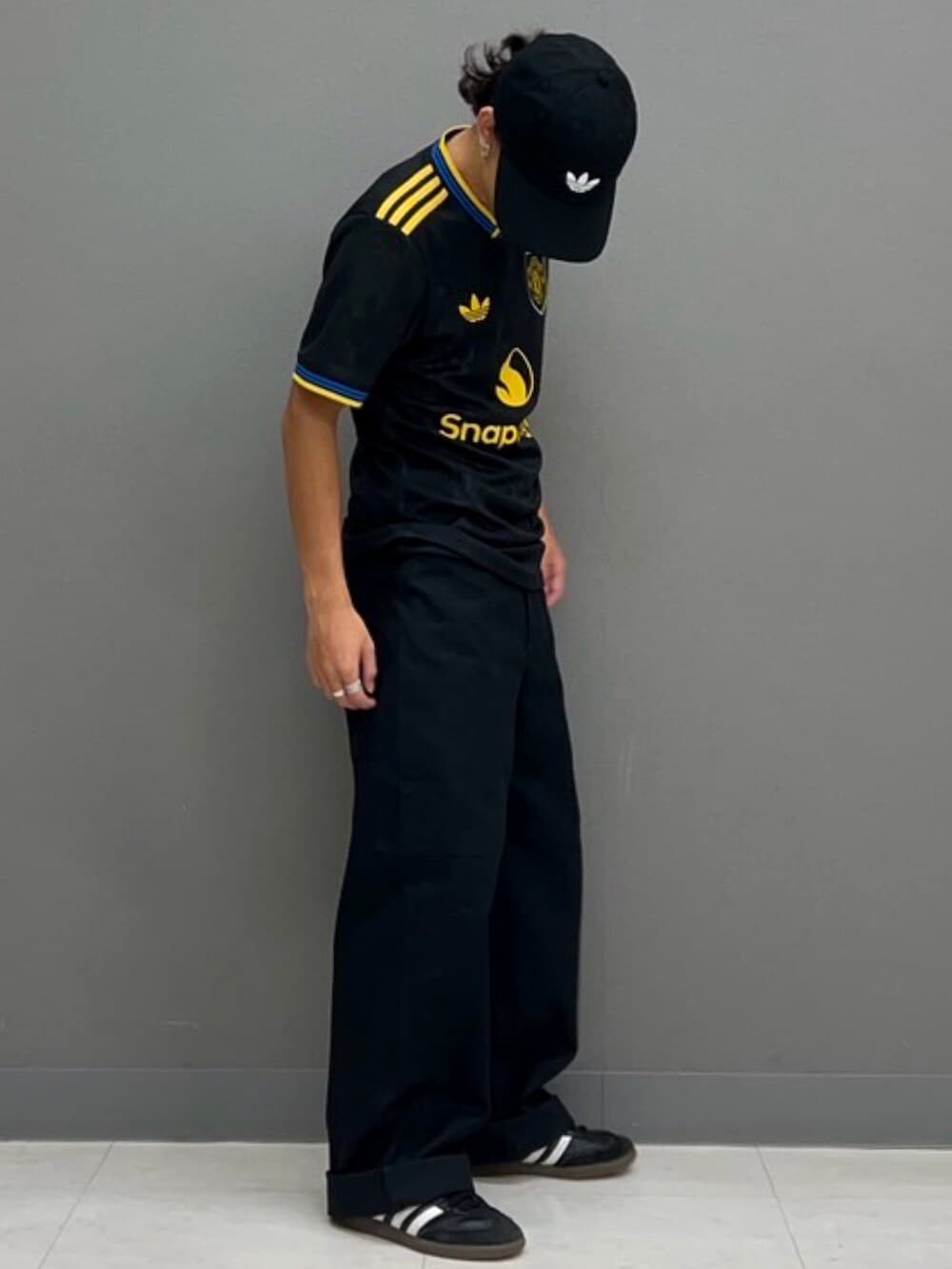 ブラック系のシューズ、ブラック系のTシャツ/カットソー、ブラック系のキャップを着用したメンズの秋コーディネートの2枚目の写真