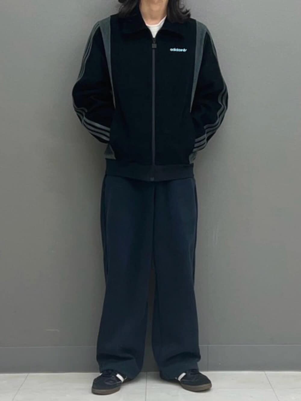 ブラック系のシューズ、ブラック系のブルゾン、ブルー系のキャップを着用したメンズの秋コーディネートの2枚目の写真