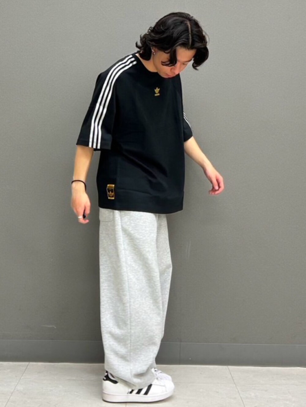 ホワイト系のスニーカー、ブラック系のTシャツ/カットソーを着用したメンズの春コーディネートの2枚目の写真