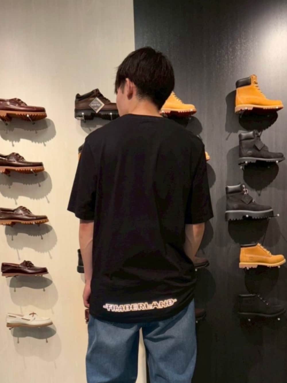 ブラック系のTシャツ/カットソー、ブルー系のデニムパンツ、ベージュ系のシューズを着用したメンズの夏コーディネートの2枚目の写真