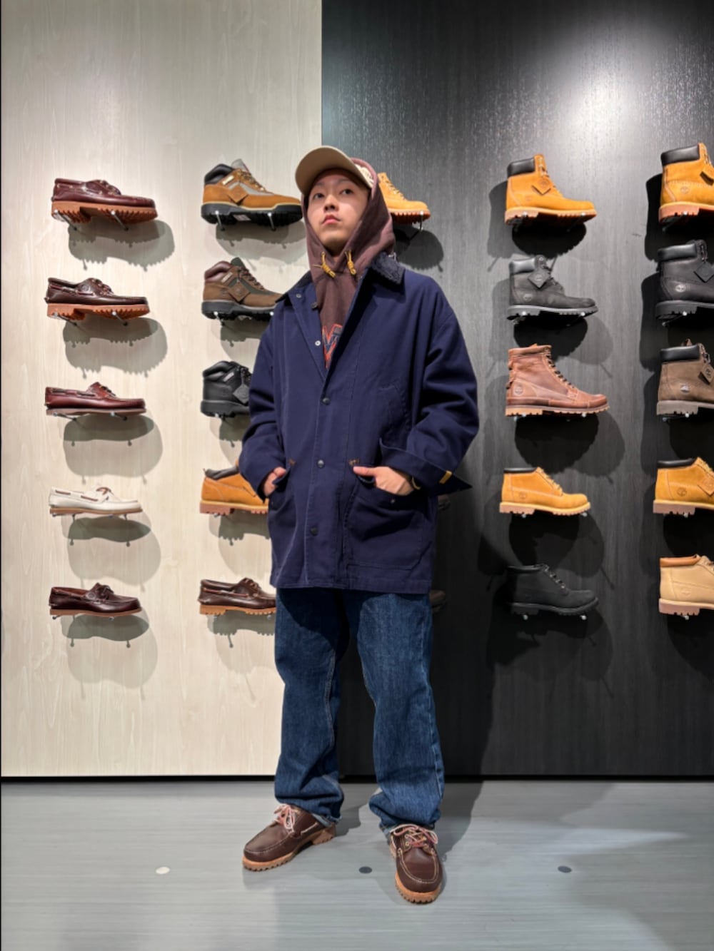 ブラウン系のパーカー、ブルー系のピーコート、ブルー系のデニムパンツを着用したメンズの秋コーディネートの2枚目の写真