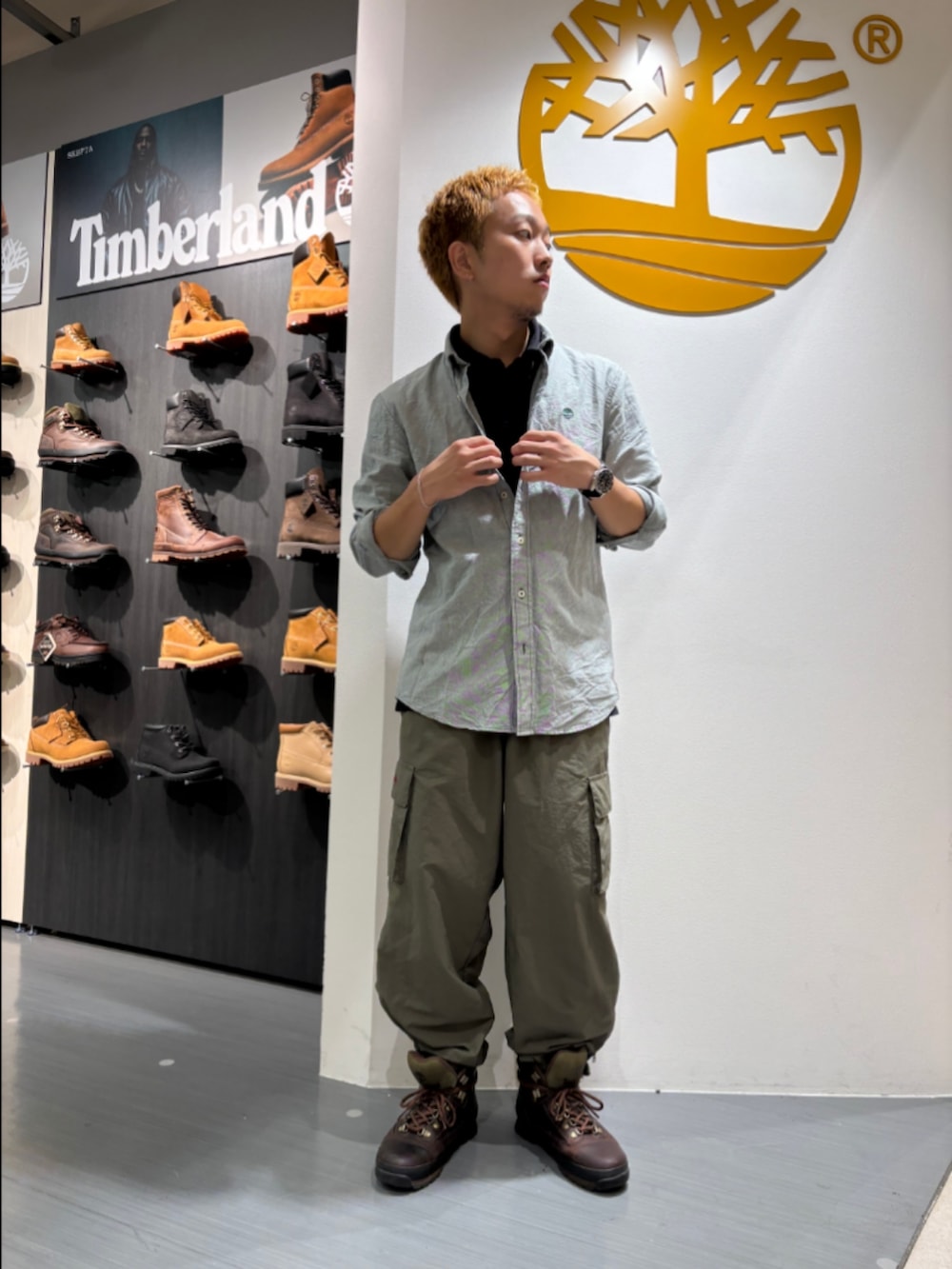 グリーン系のシャツ/ブラウス、ブラック系のポロシャツ、ブラウン系のブーツを着用したメンズの秋コーディネートの2枚目の写真