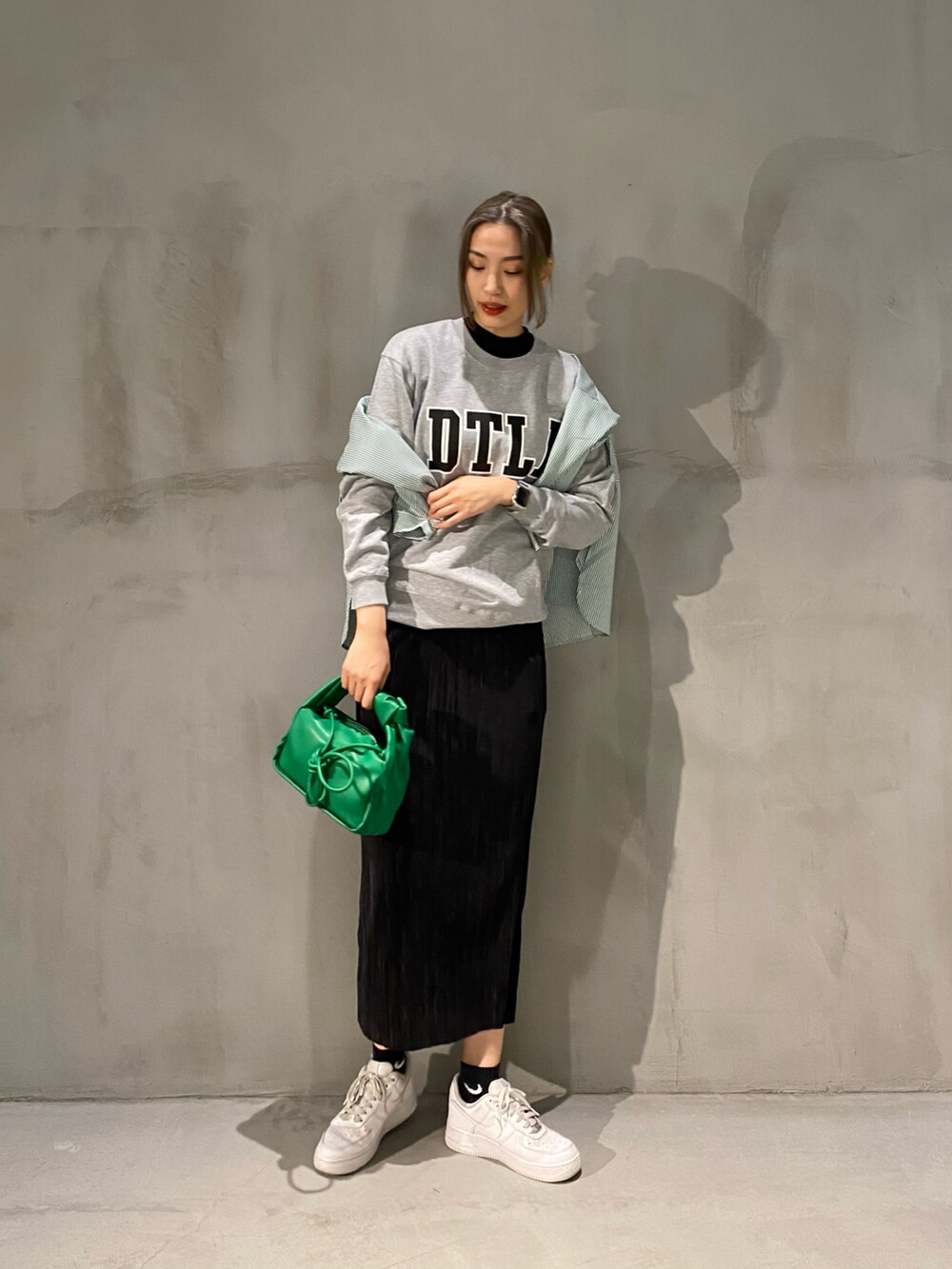 グリーン系のショルダーバッグ、グリーン系のシャツ/ブラウス、グレー系のスウェットを着用したレディースの春コーディネートの2枚目の写真