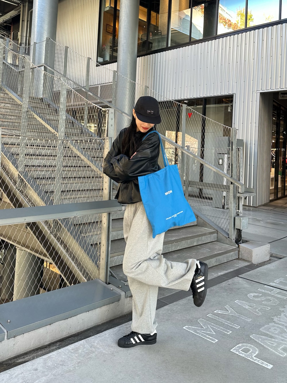 ブラック系のブルゾン、ブルー系のトートバッグを着用したレディースの冬コーディネートの2枚目の写真