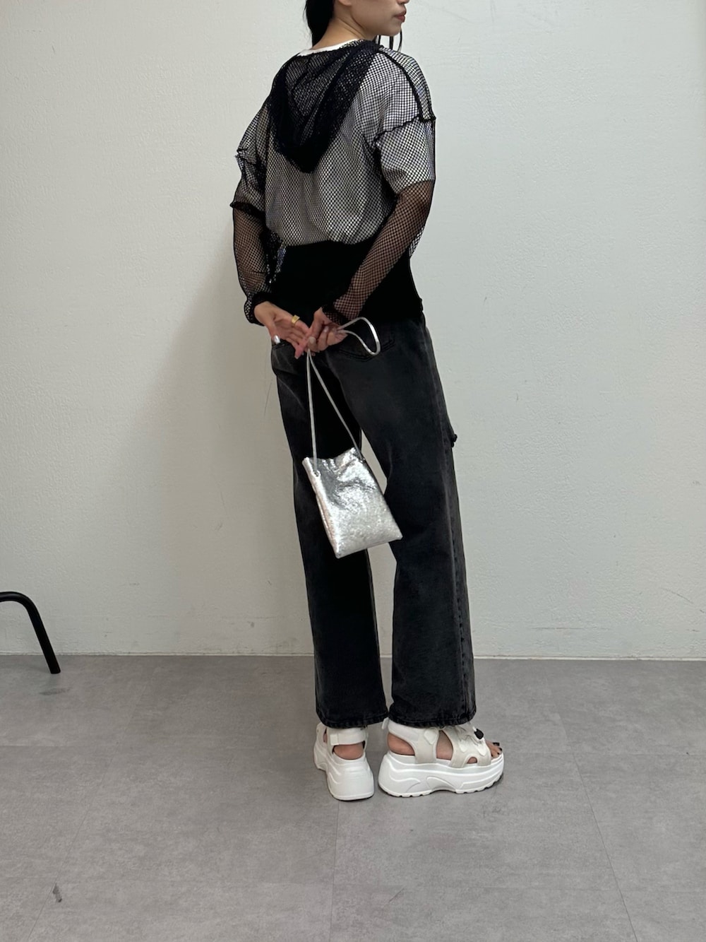 ブラック系のデニムパンツ、ホワイト系のサンダル、ホワイト系のTシャツ/カットソーを着用したレディースの春コーディネートの2枚目の写真