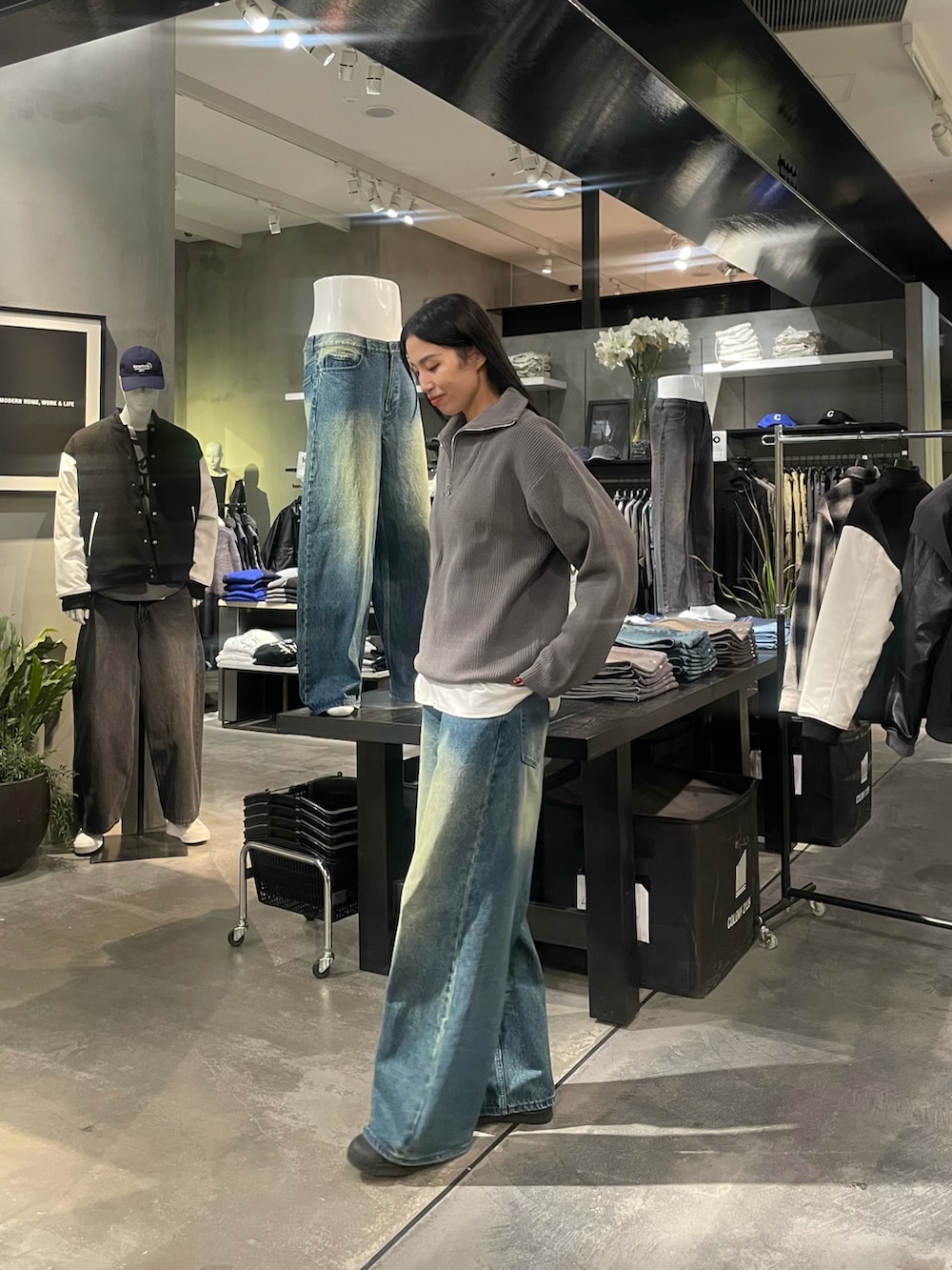 グレー系のニット/セーター、ホワイト系のTシャツ/カットソー、ブルー系のデニムパンツを着用したレディースの冬コーディネートの2枚目の写真