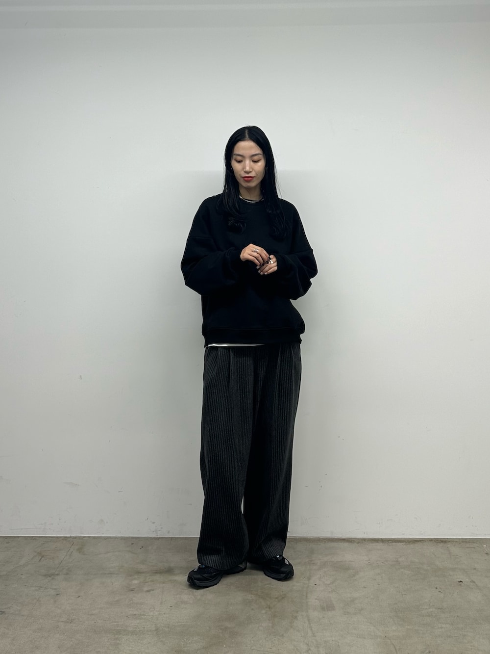 グレー系のスラックス、ブラック系のスウェットを着用したレディースの秋コーディネートの4枚目の写真