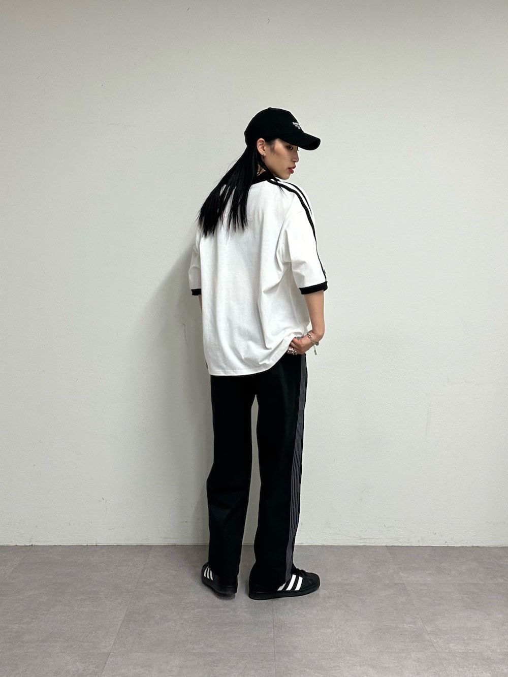 ブラック系のその他パンツ、ホワイト系のTシャツ/カットソー、ブラック系のキャップを着用したレディースの春コーディネートの3枚目の写真