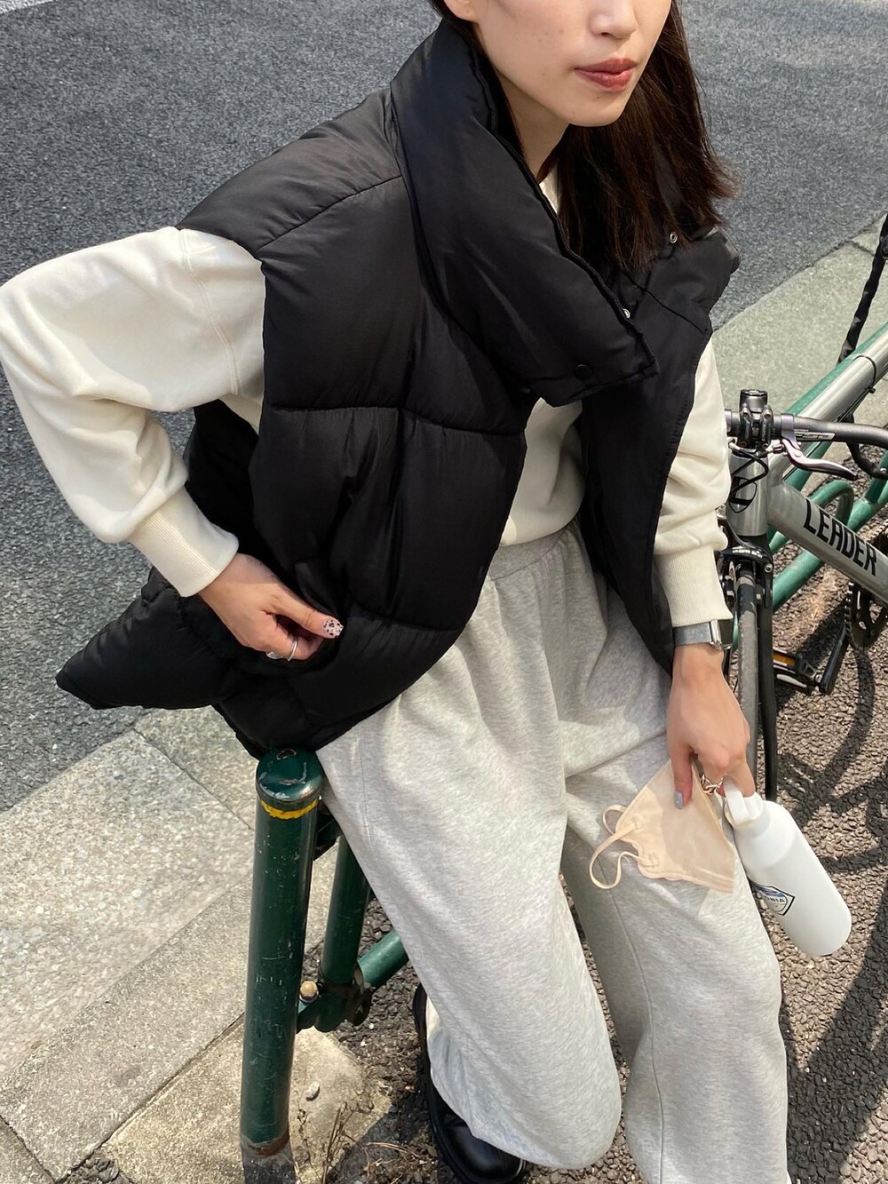 ブラック系のダウンベスト、ホワイト系のスウェット、グレー系のスウェットパンツを着用したレディースの秋コーディネートの3枚目の写真