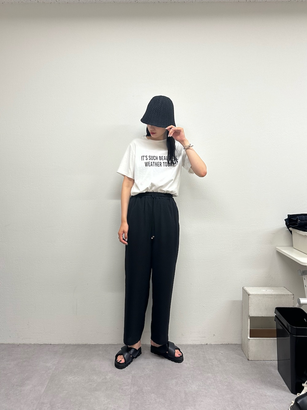 ブラック系のその他パンツ、ホワイト系のTシャツ/カットソー、ブラック系のサンダルを着用したレディースの春コーディネートの2枚目の写真