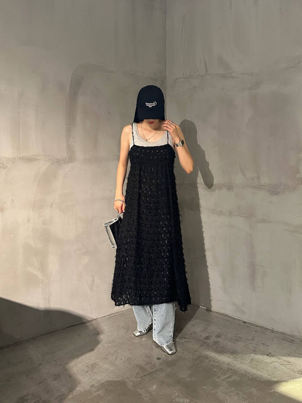 ブラック系のワンピース、グレー系のタンクトップ、ブルー系のデニムパンツを着用したレディースの夏コーディネートの4枚目の写真