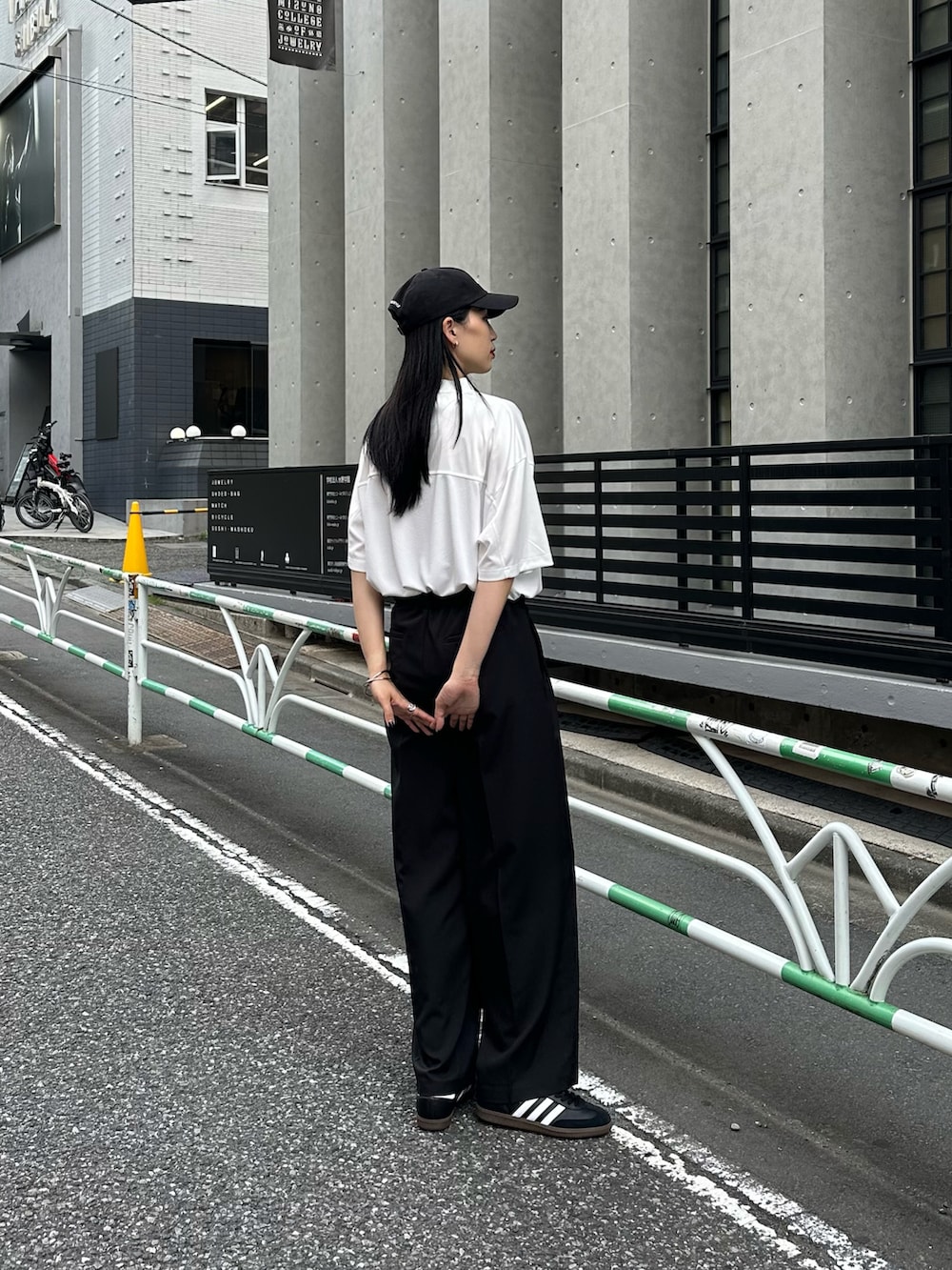 ホワイト系のTシャツ/カットソー、ブラック系のスラックス、ブラック系のキャップを着用したレディースの夏コーディネートの2枚目の写真