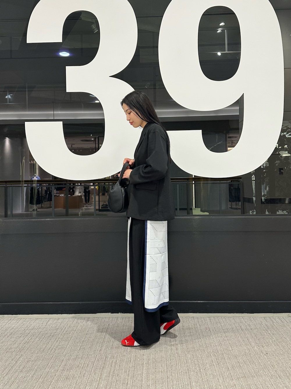 ブラック系のテーラードジャケット、ホワイト系のTシャツ/カットソー、ブラック系のスラックスを着用したレディースの春コーディネートの4枚目の写真