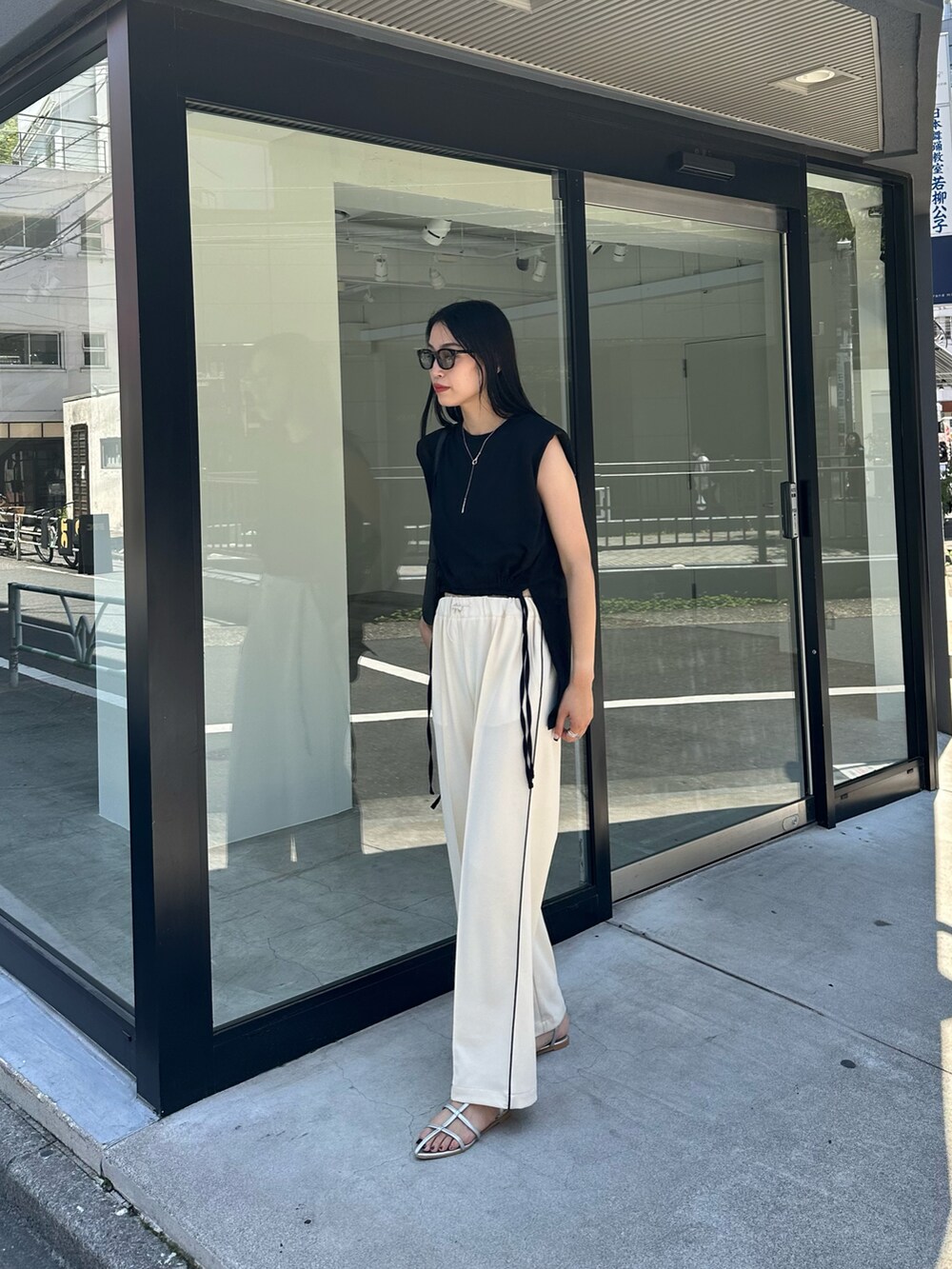 ブラック系のTシャツ/カットソー、ホワイト系のその他パンツ、シルバー系のサンダルを着用したレディースの夏コーディネートの2枚目の写真