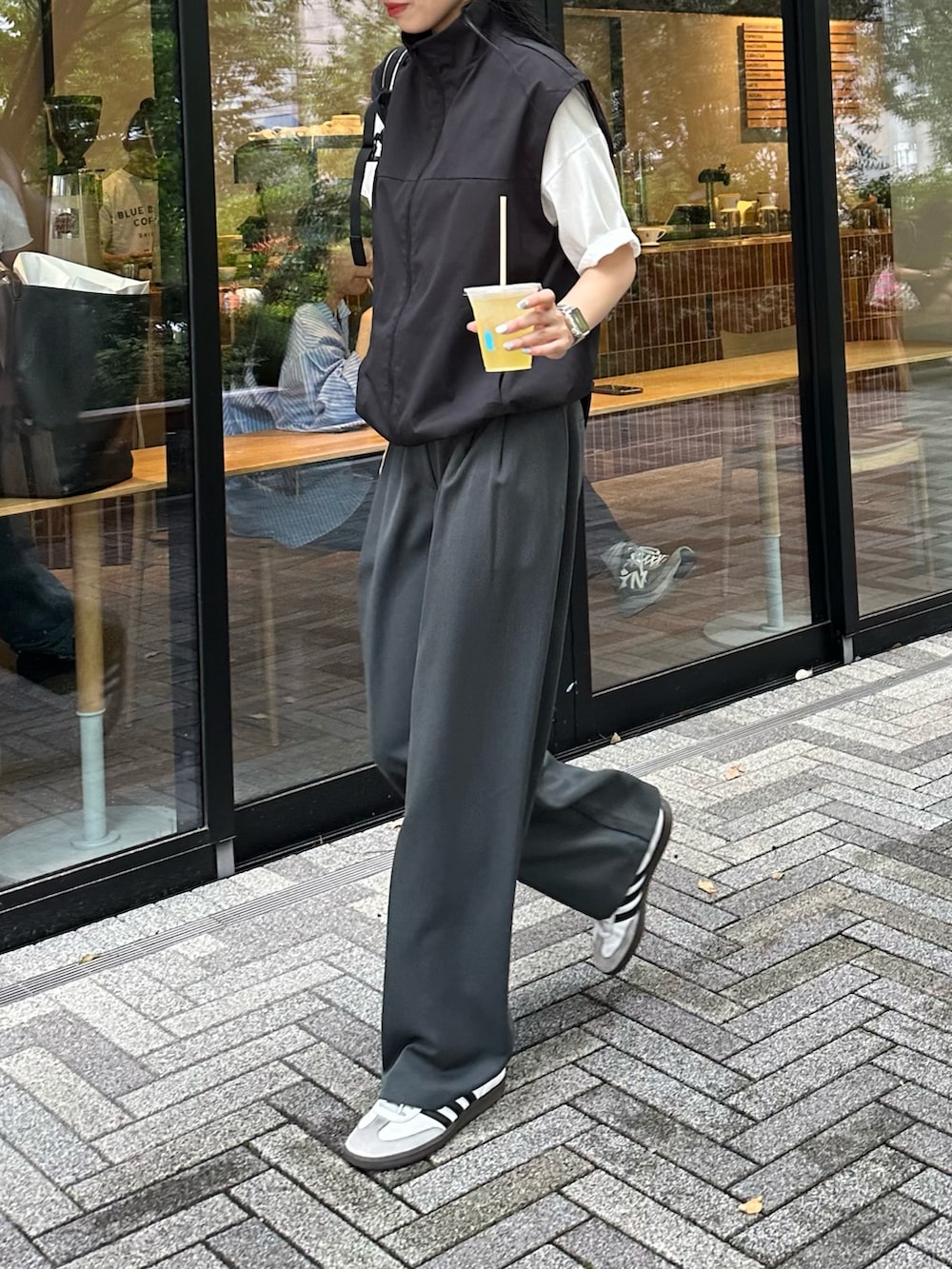 グレー系のスラックス、ブラック系のベスト、ホワイト系のTシャツ/カットソーを着用したレディースの夏コーディネートの4枚目の写真