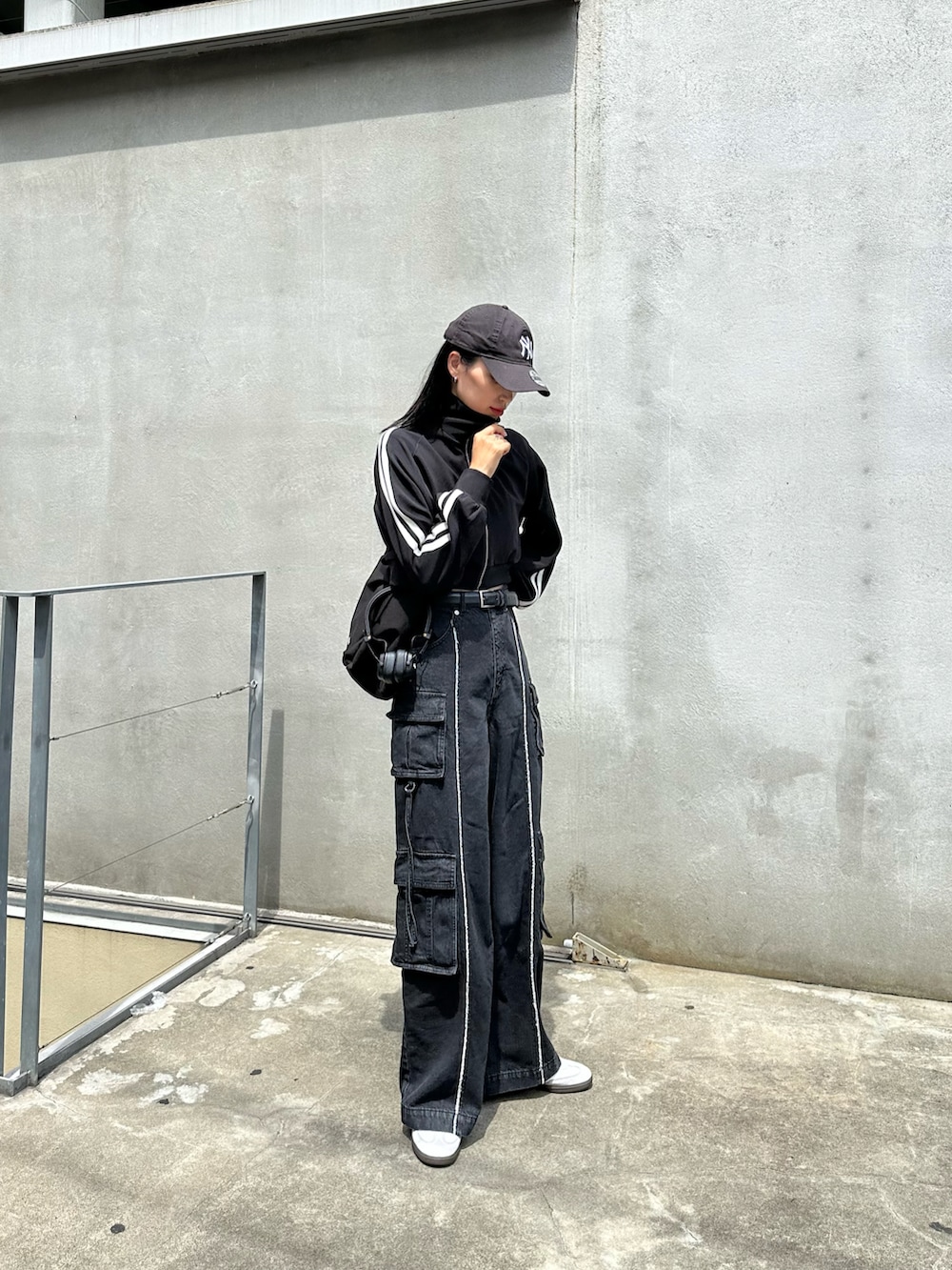 ブラック系のメッセンジャーバッグ、ブラック系のジャケット/アウターを着用したレディースの夏コーディネートの2枚目の写真