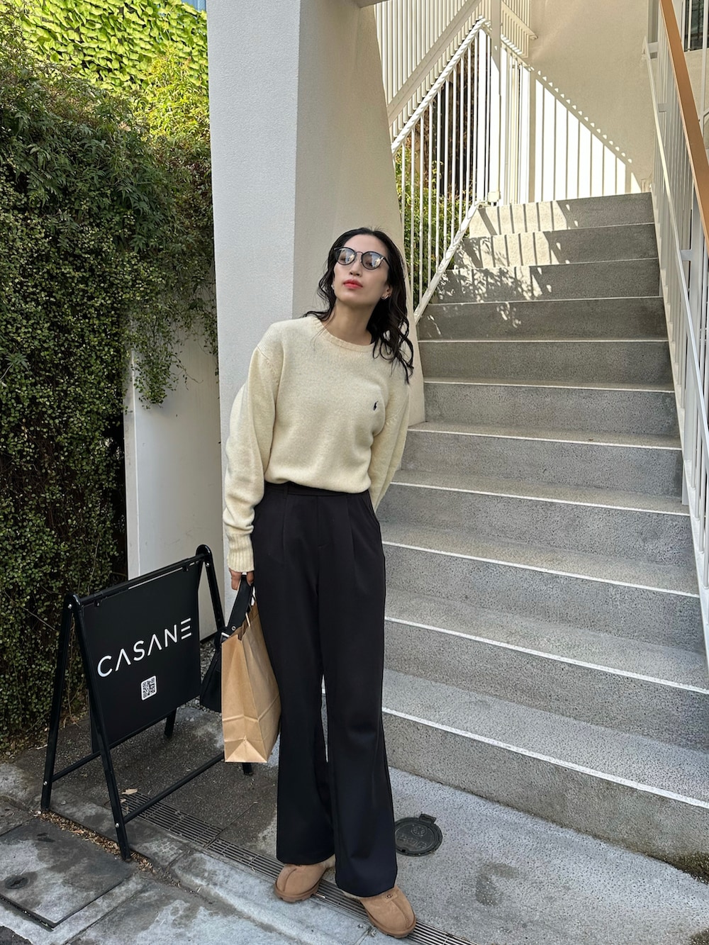 ブラック系のその他パンツ、ベージュ系のニット/セーター、ベージュ系のサンダルを着用したレディースの冬コーディネートの2枚目の写真