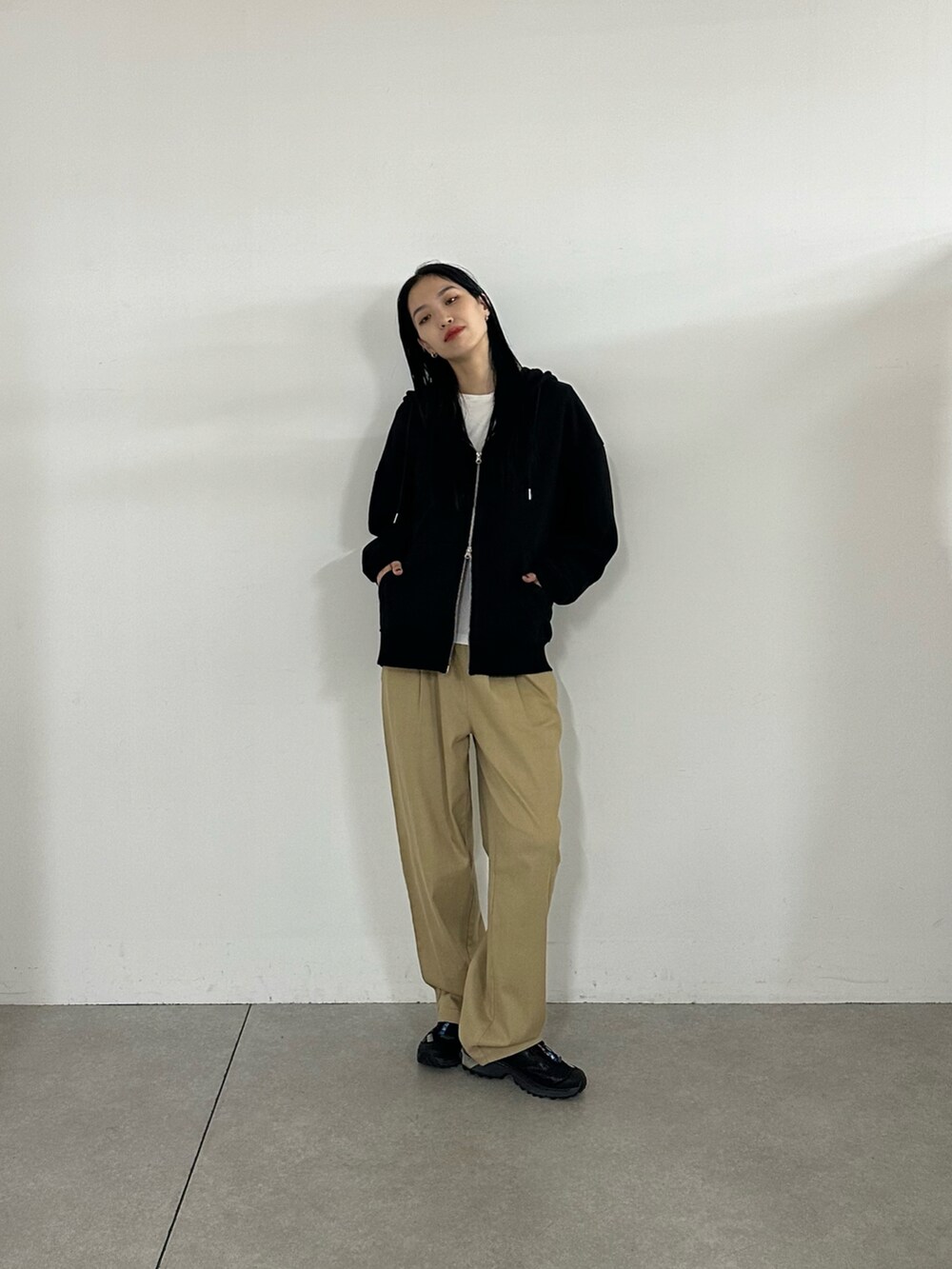 ベージュ系のその他パンツ、ブラック系のパーカーを着用したレディースの秋コーディネートの4枚目の写真
