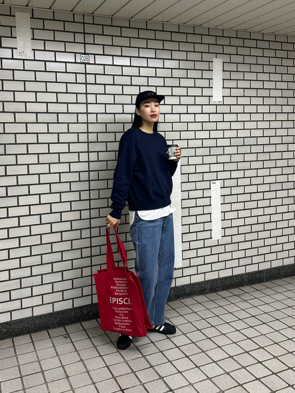 ブルー系のスウェット、レッド系のトートバッグ、ホワイト系のTシャツ/カットソーを着用したレディースの春コーディネートの4枚目の写真